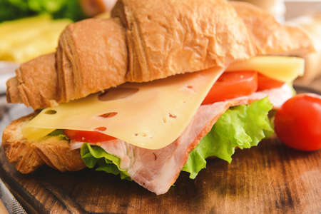 Tasty croissant sandwich on wooden board, closeupの写真素材