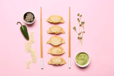 Tasty Japanese gyoza and sauces on color backgroundの写真素材