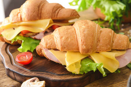Tasty croissant sandwiches on wooden boardの写真素材