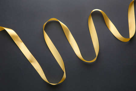 Beautiful golden ribbon on dark background