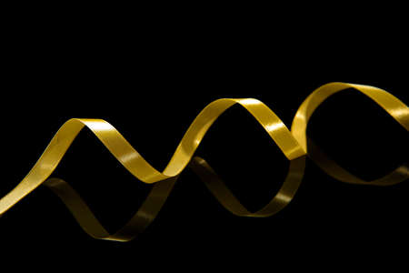 Beautiful golden ribbon on dark backgroundの写真素材