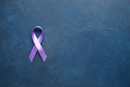Lilac ribbon on color background. Cancer awareness concept