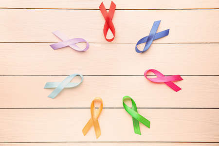 Different awareness ribbons on white wooden background