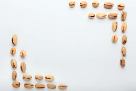 Frame made of tasty pistachio nuts on white backgroundの写真素材