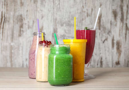 Glassware with different healthy smoothie on tableの写真素材