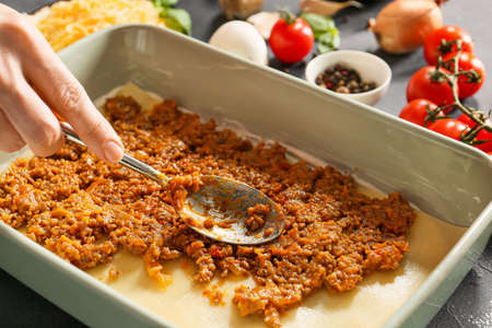 Woman cooking tasty lasagna, closeupの写真素材