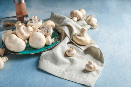 Plate with fresh mushrooms on color backgroundの写真素材