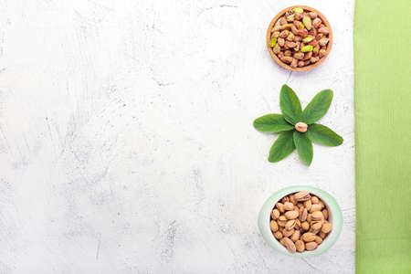 Bowls with tasty pistachio nuts on tableの写真素材
