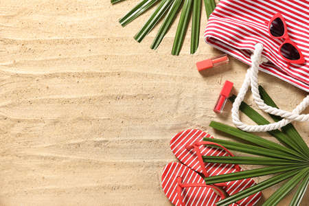 Beach bag with sunglasses and makeup cosmetics on sandの写真素材