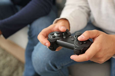 Friends playing video game at home, closeup