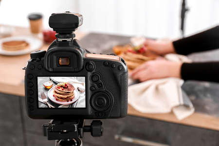 Tasty pancakes on display of professional photo camera in studio