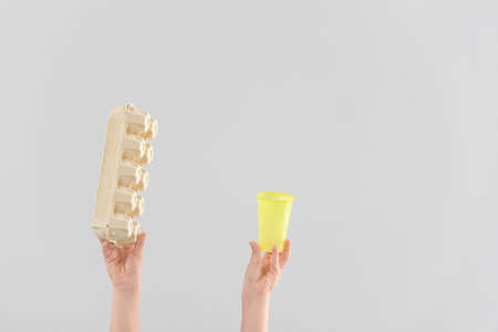 Hands with garbage on light background. Concept of recycling
