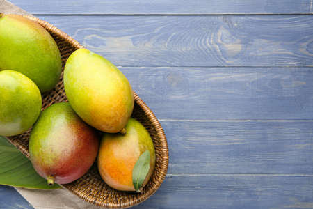 Basket with mango fruit on tableの写真素材