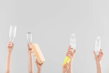 Hands with garbage on light background. Concept of recycling