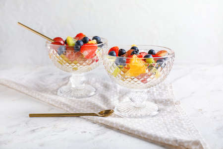 Dessert bowls with tasty fruit salad on tableの写真素材