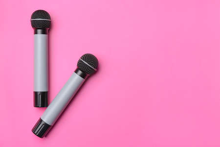 Modern microphones on color background