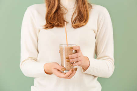 Woman with glass of healthy smoothie on color backgroundの写真素材