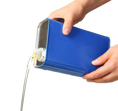Pouring of car oil from canister against white background