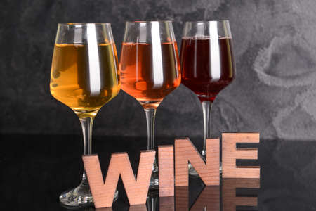 Glasses of different wine on dark tableの写真素材