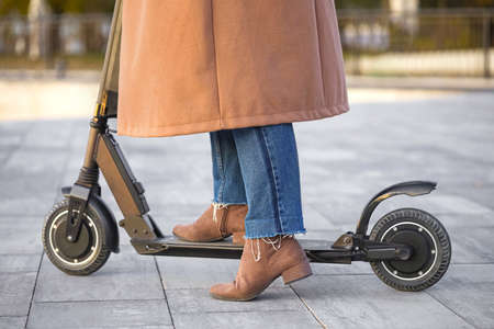 Young woman riding a kick scooter outdoors