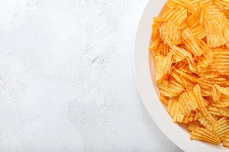 Plate with tasty potato chips on tableの写真素材