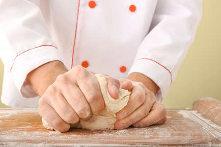 Man kneading dough in kitchen, closeup