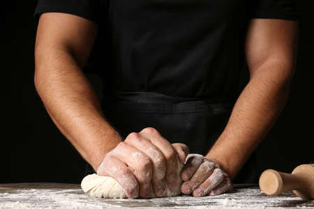 Man kneading dough in kitchen, closeup