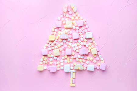Christmas tree shape made of tasty marshmallows on color backgroundの写真素材