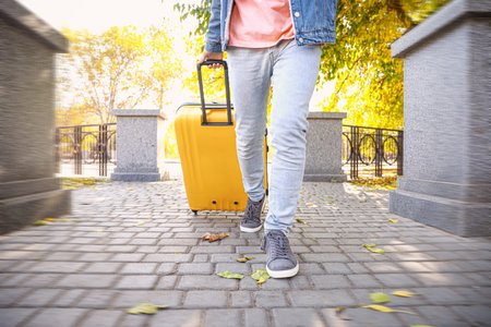 Young man with luggage outdoorsの写真素材
