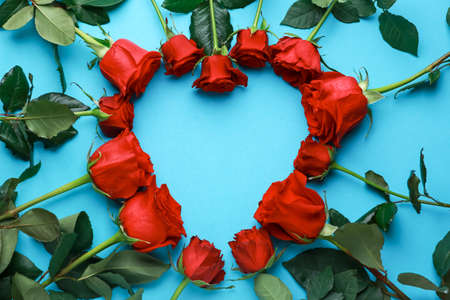Heart made of rose flowers on color background. Valentine's day celebrationの写真素材