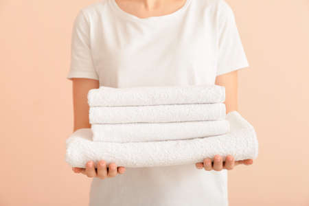 Woman with clean towels on color backgroundの写真素材