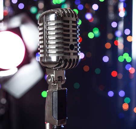 Retro microphone on stage against defocused lightsの写真素材