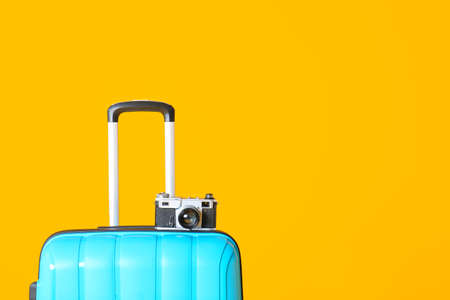 Packed suitcase and photo camera on color background. Travel conceptの写真素材