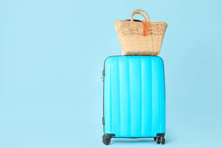 Packed suitcase and beach bag on color background. Travel concept