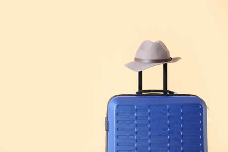 Packed suitcase and hat on color background. Travel conceptの写真素材