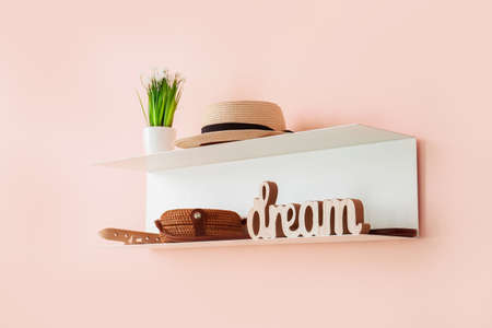 Shelf with female accessories hanging on color wall