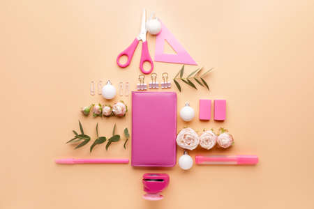 Beautiful Christmas tree made of stationery on color background