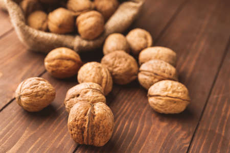 Sack with tasty walnuts on wooden table