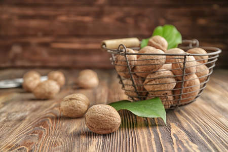 Basket with tasty walnuts on wooden tableの写真素材