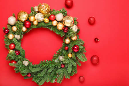 Beautiful Christmas wreath and decor on color backgroundの写真素材