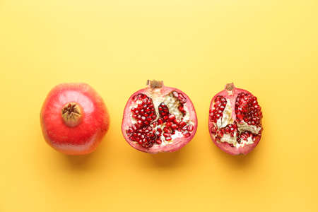 Ripe juicy pomegranates on color backgroundの写真素材