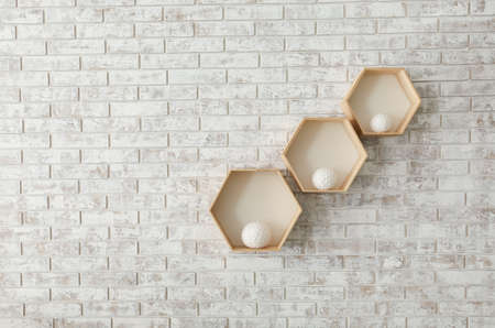 Shelves with decor hanging on brick wall