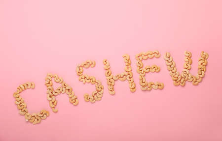 Word CASHEW made of nuts on color background