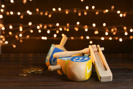 Dreidels for Hanukkah on table against dark background with defocused lightsの写真素材
