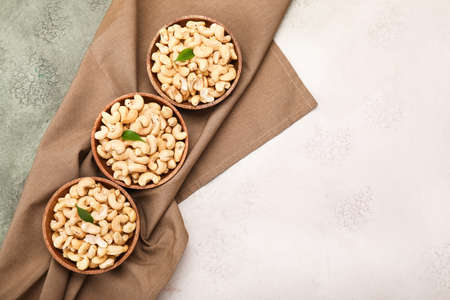 Bowls with tasty cashew nuts on color backgroundの写真素材