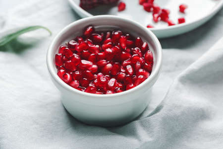 Bowl with pomegranate seeds on tableの写真素材