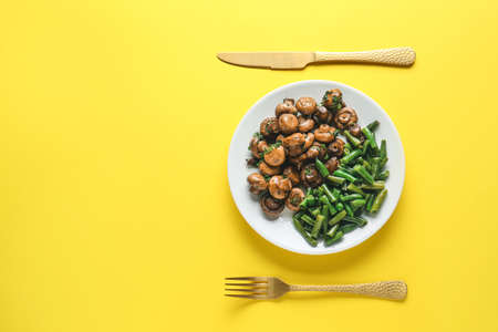 Plate with tasty cooked mushrooms and green beans on color backgroundの写真素材