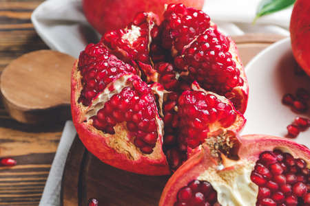 Tasty pomegranate on wooden board, closeupの写真素材