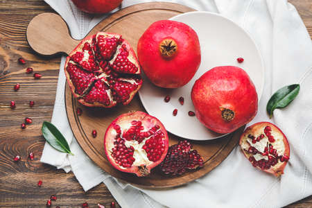 Board with tasty pomegranate on wooden tableの写真素材