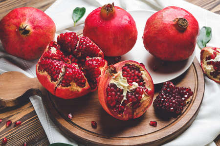 Board with tasty pomegranate on wooden tableの写真素材